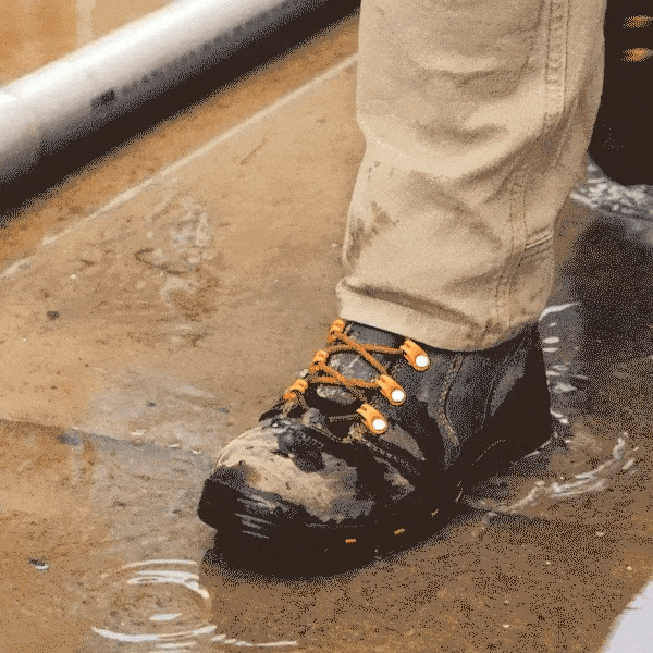 Close-up of a black hiking boot in shallow water