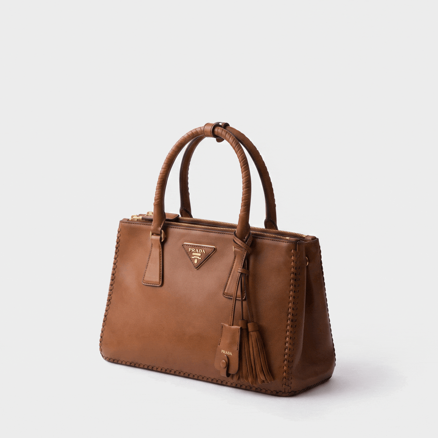 Brown leather handbag rotates between front and angled product views on a white background